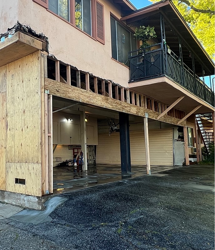 Home renovation with exposed structure and garage doors.