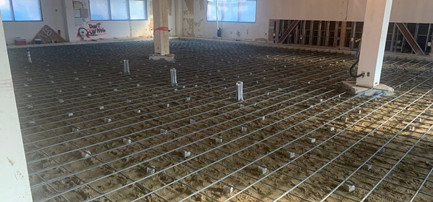 Construction site with exposed floor and rebar.