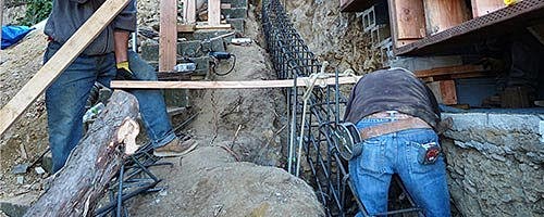 Construction workers preparing rebar for a foundation.