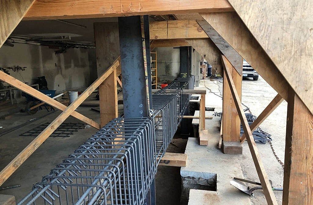 Construction site with steel rebar and wooden supports.