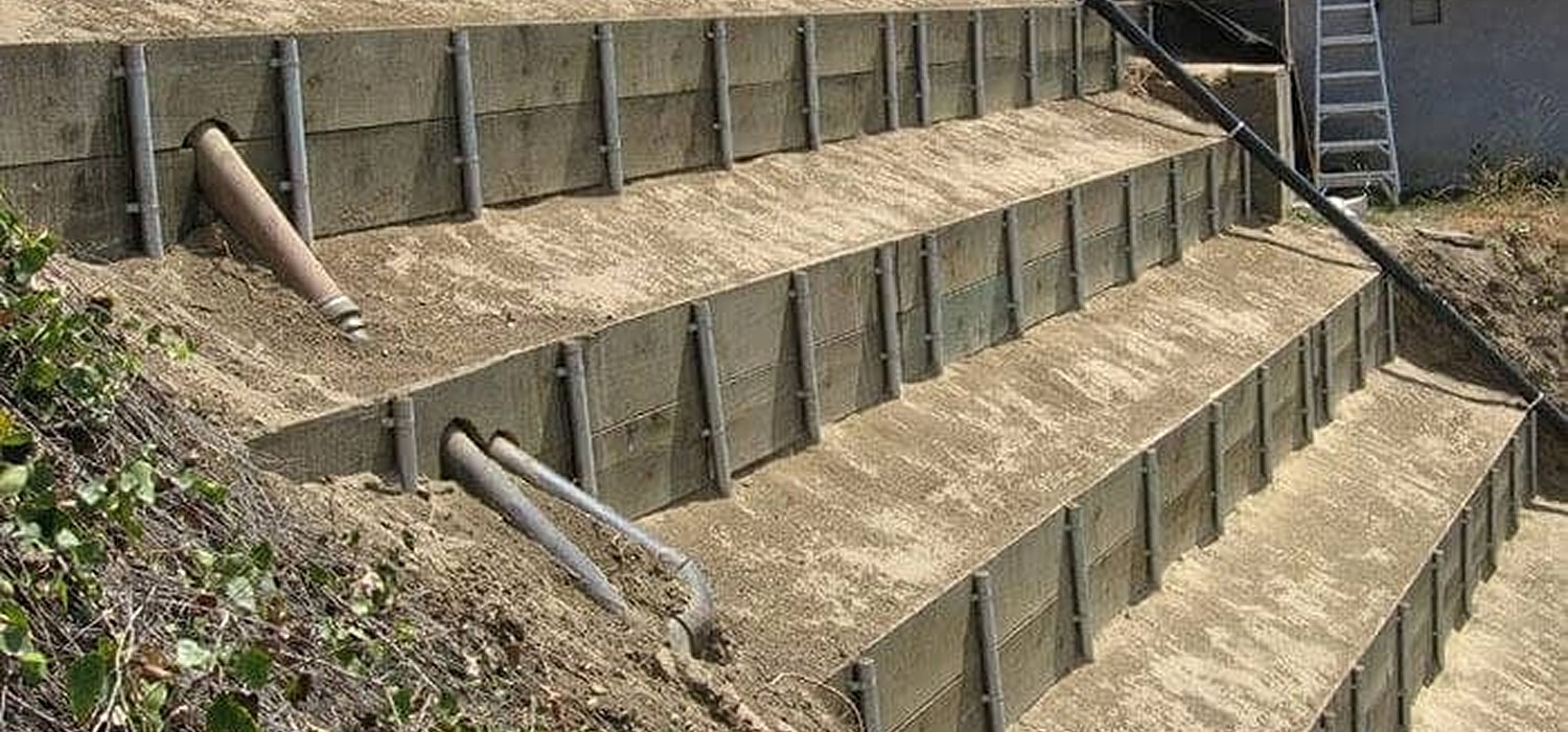 Retaining wall with drainage system on slope.