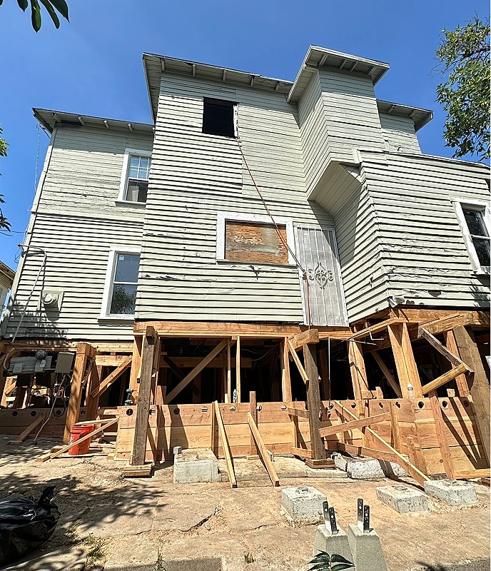House undergoing renovation and structural support work.