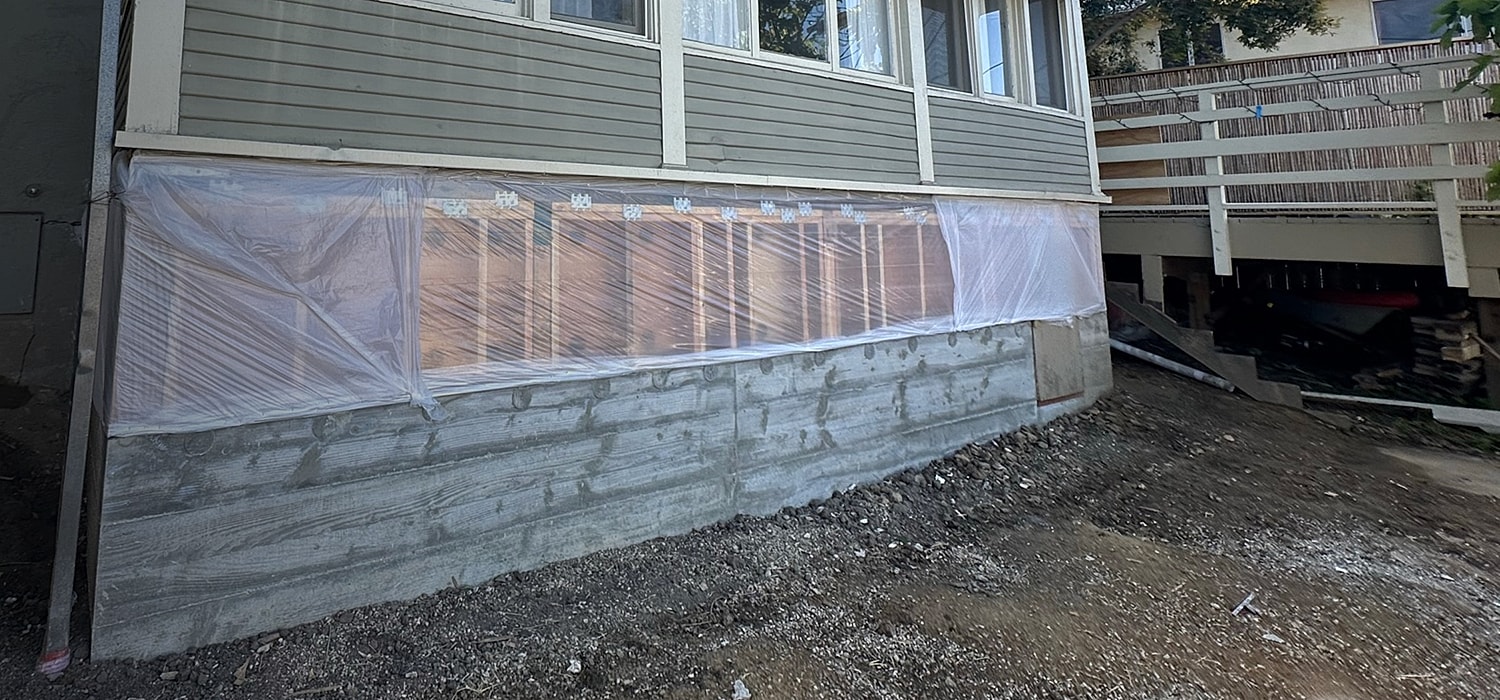 Construction area with plastic covering insulation work.