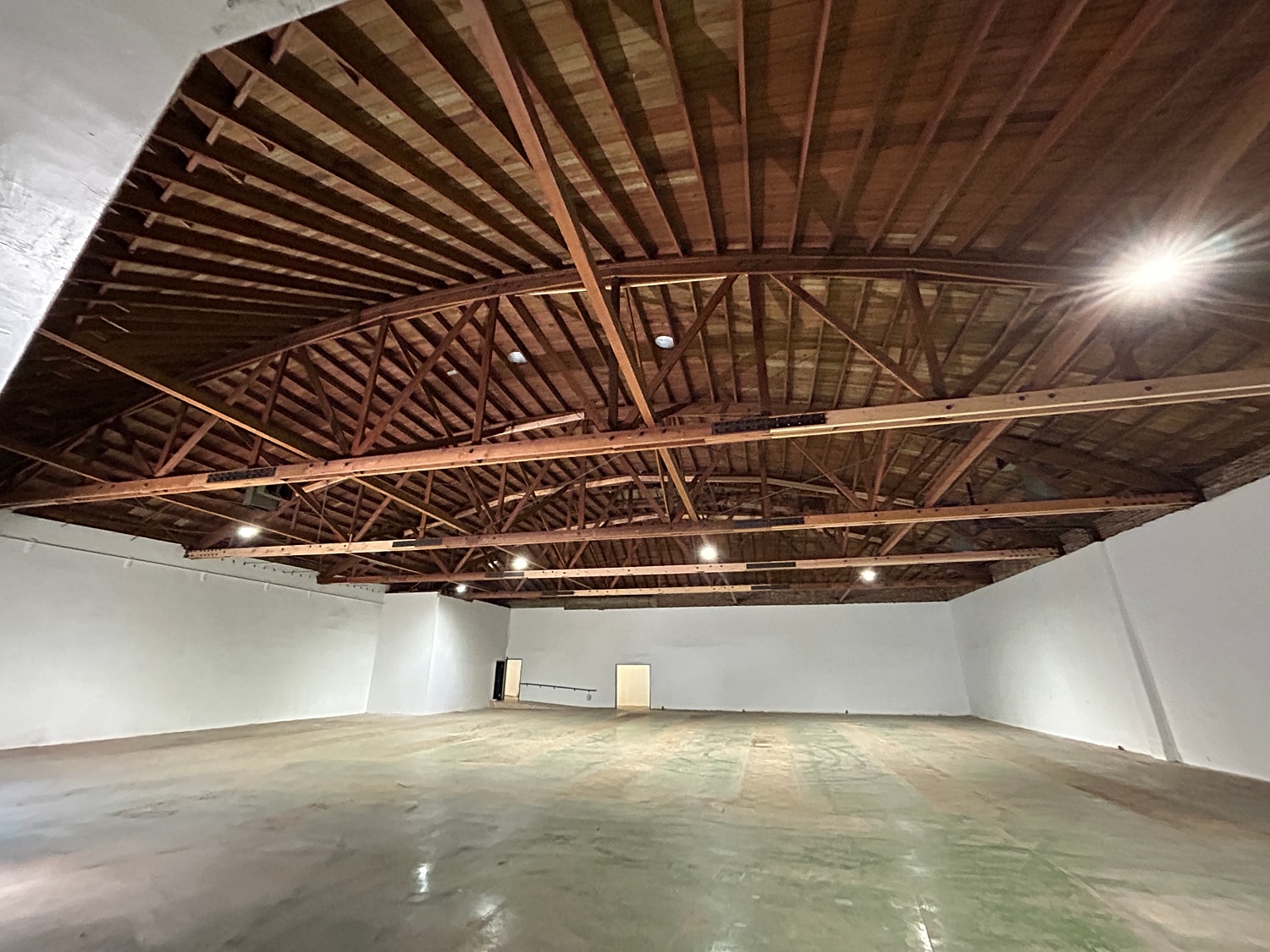 Large empty room with wooden ceiling beams.