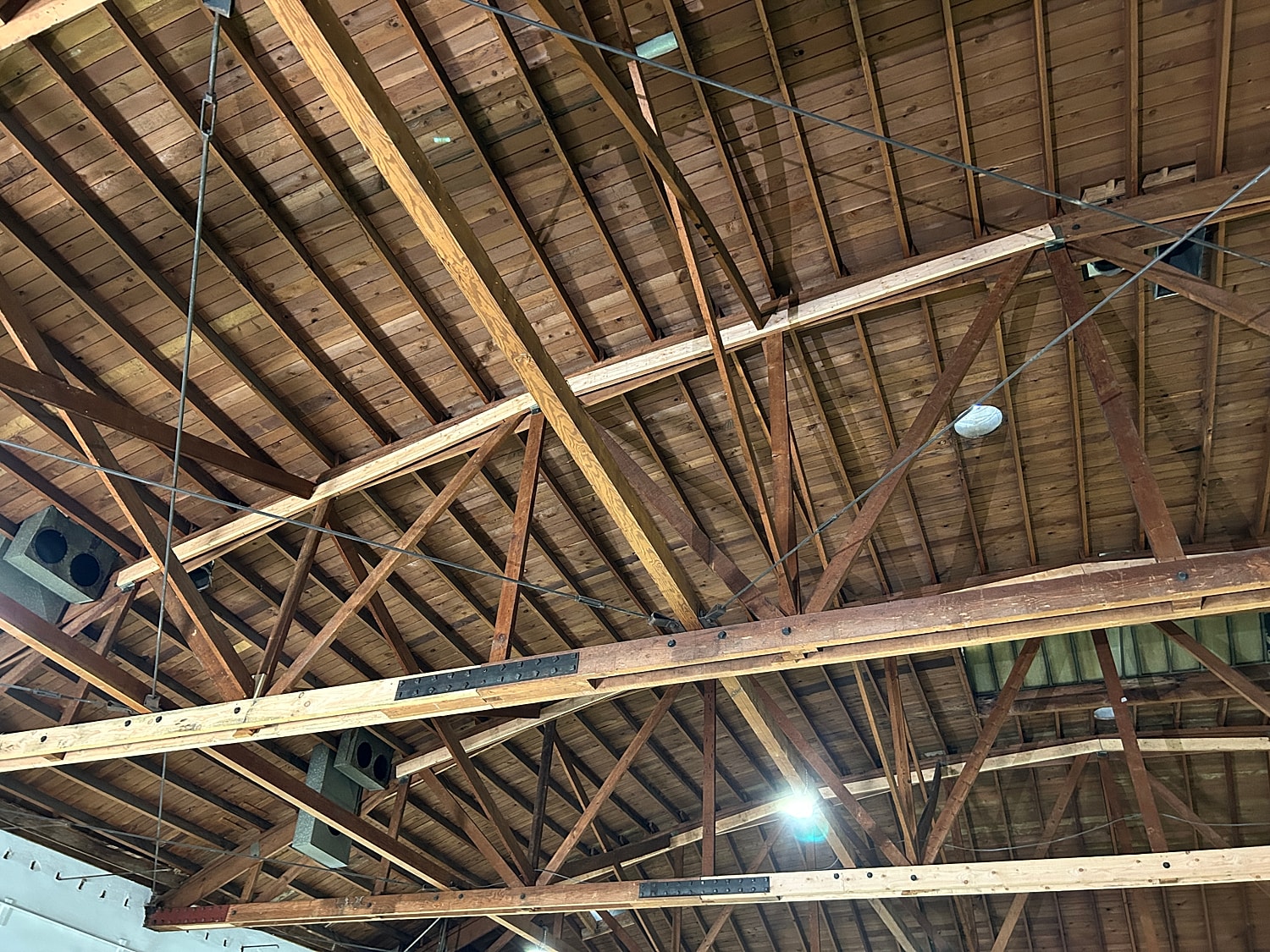 Wooden ceiling beams with metal supports and lights.