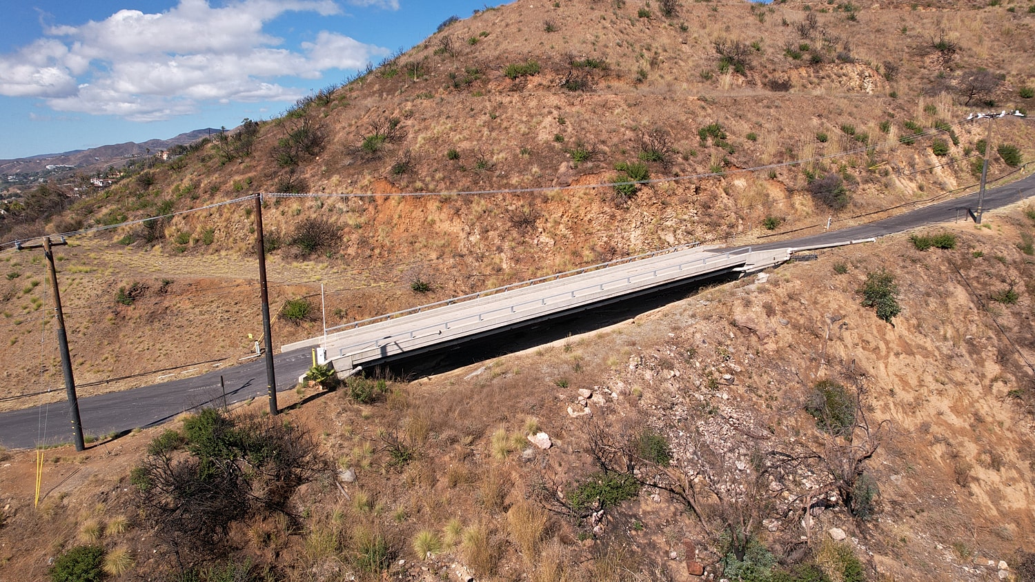 Bridge over a dry, hilly landscape.