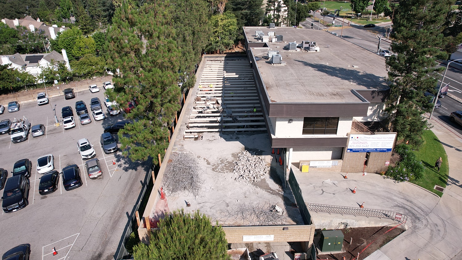 Construction site next to parking lot and buildings.