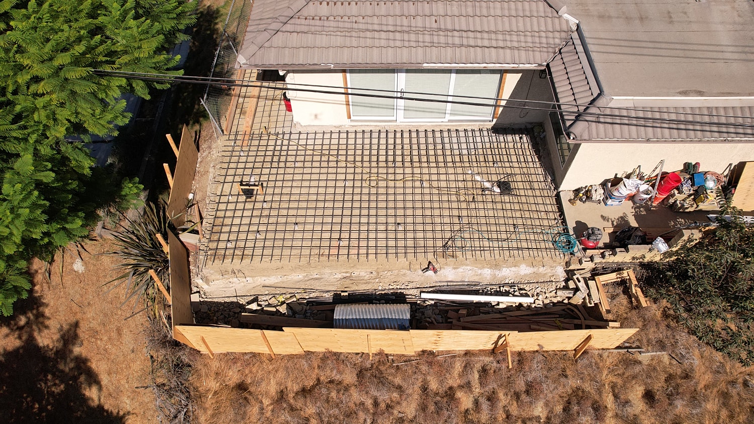 Construction site with rebar and landscaping.