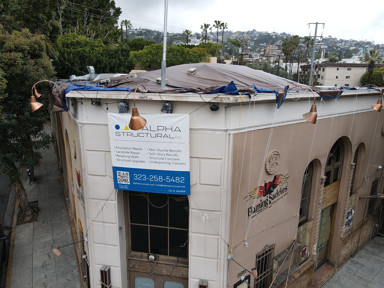 Building with repair sign and damaged roof.