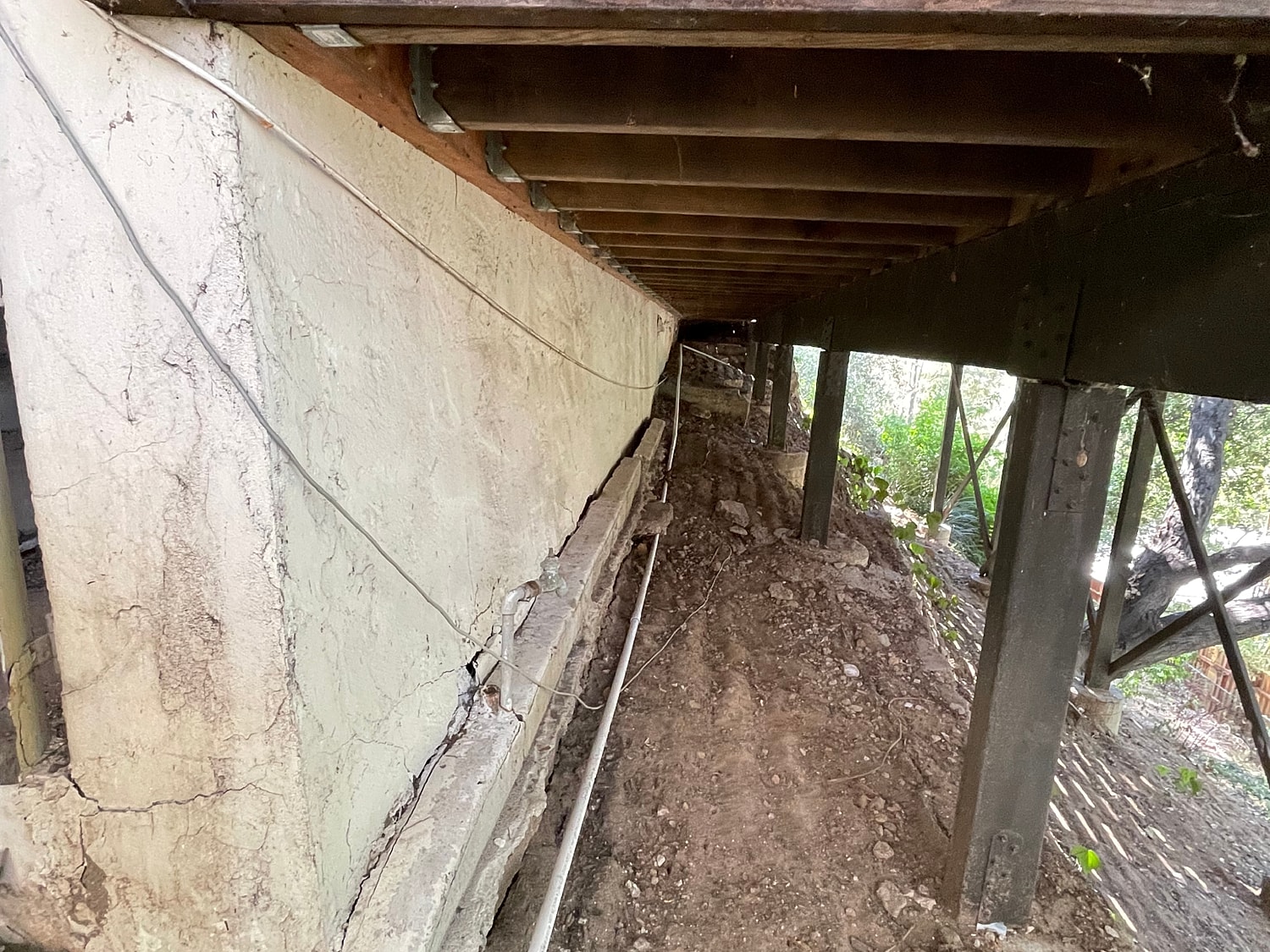 Under house foundation with visible damage and wires