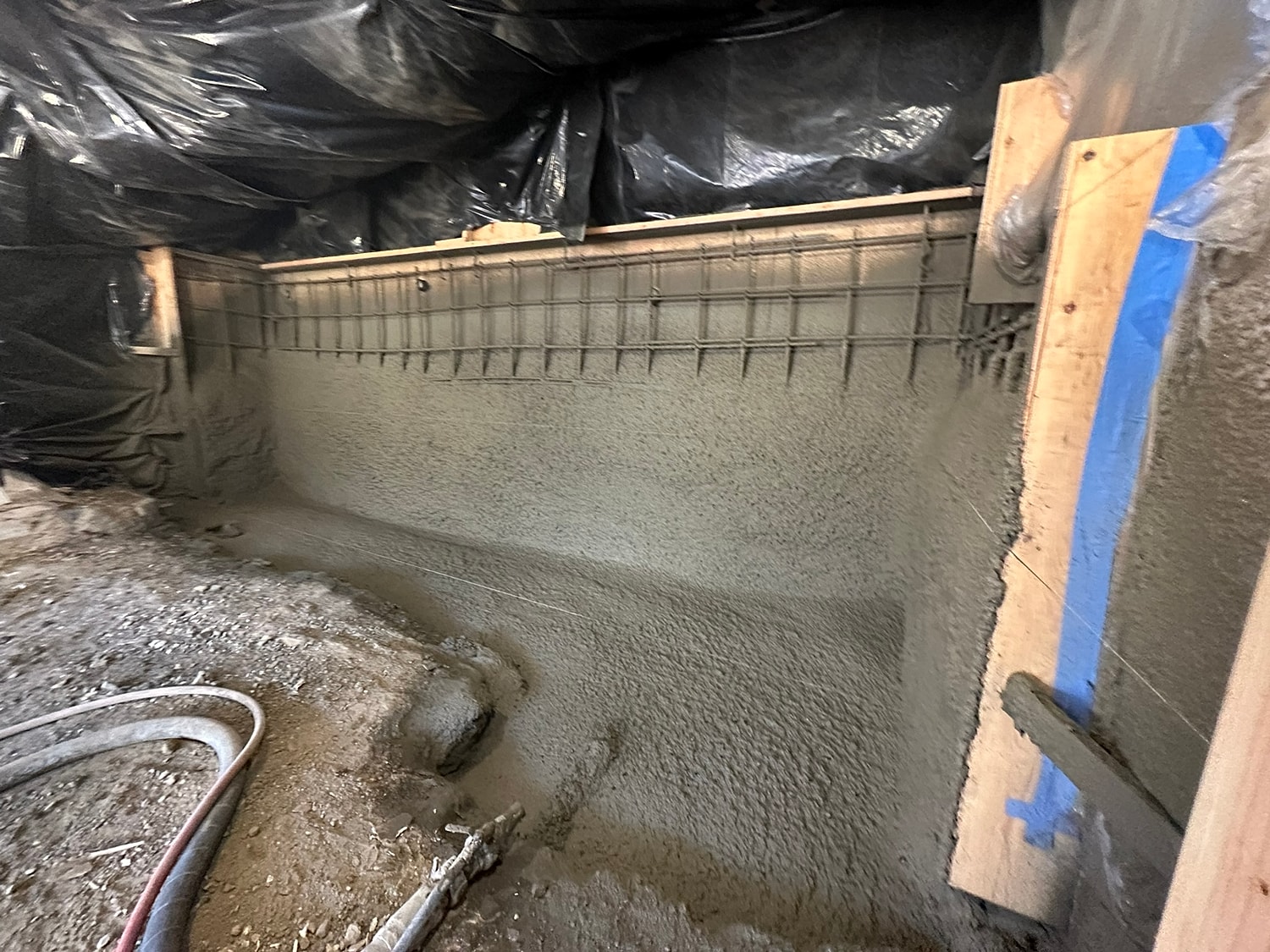 Concrete wall under construction in a covered area.