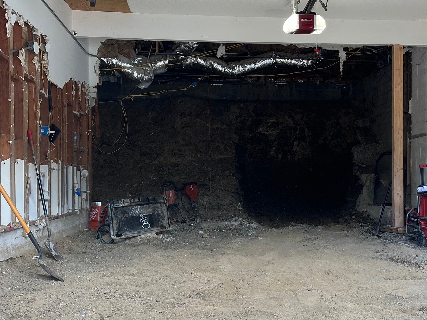 Renovated garage with tools and exposed wall.