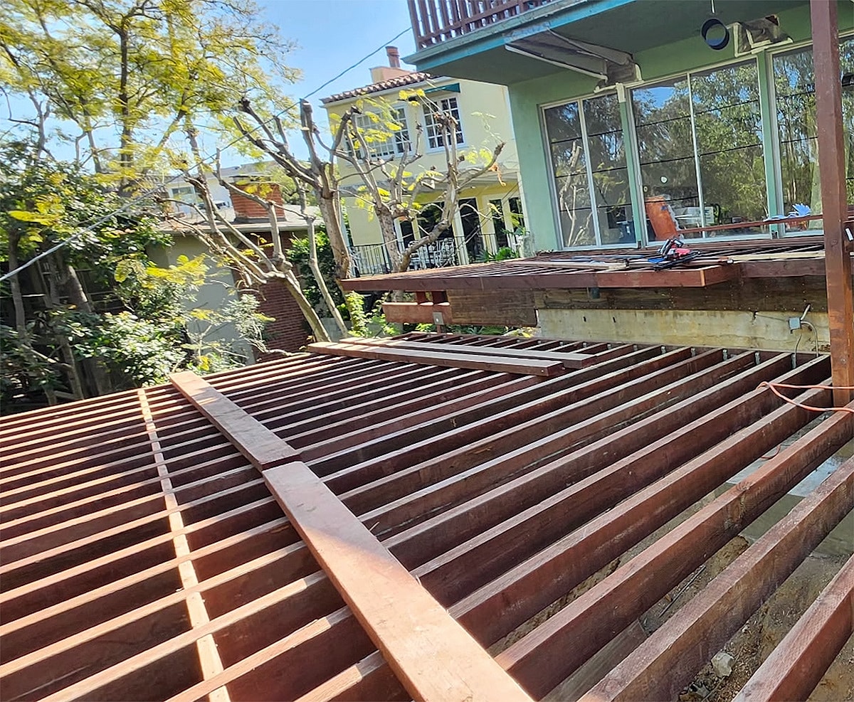 Wooden deck framing under  construction in backyard.