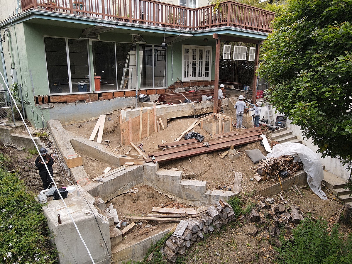 Construction site with workers and wooden structures.