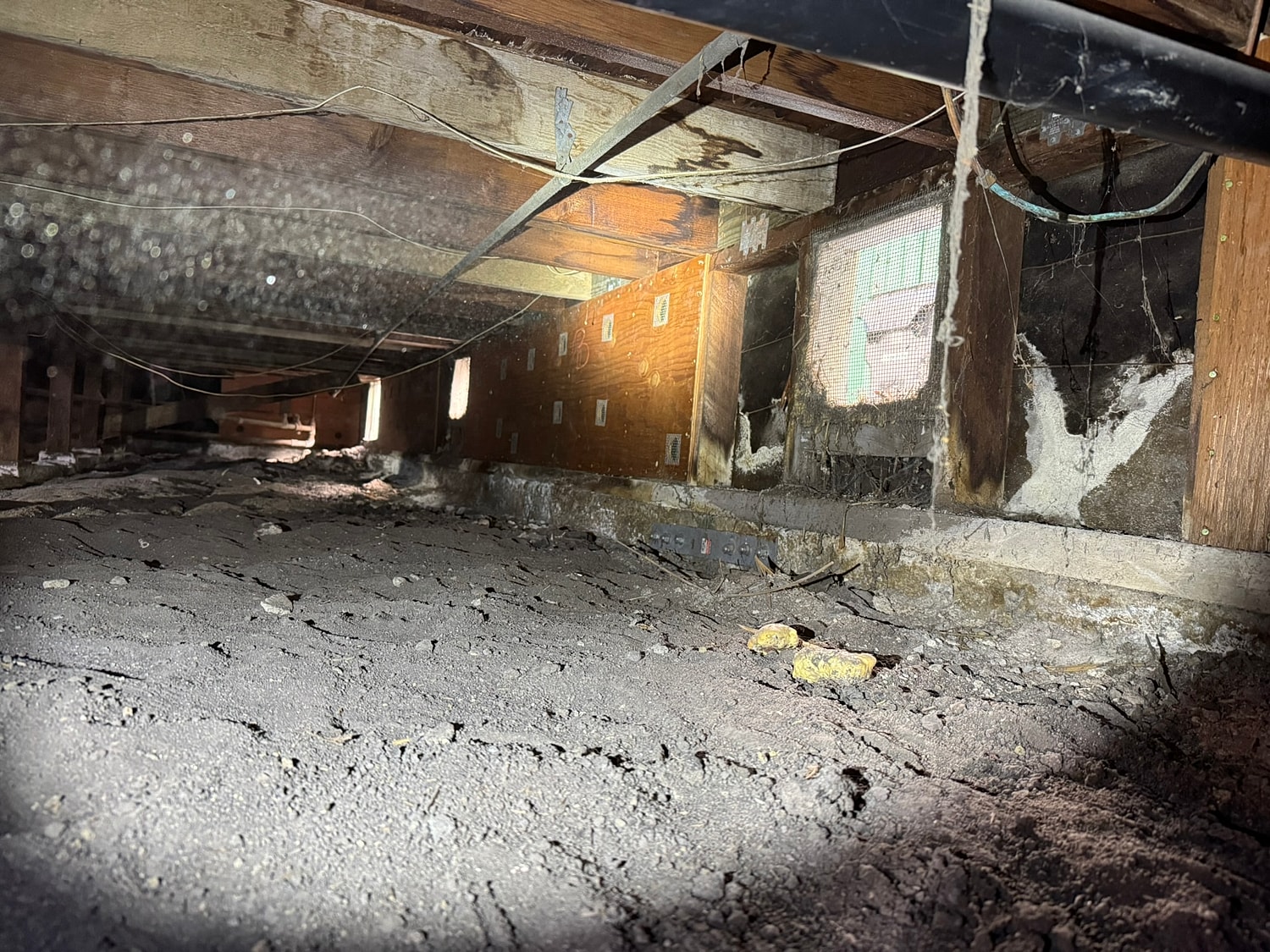View of a dusty crawl space interior.