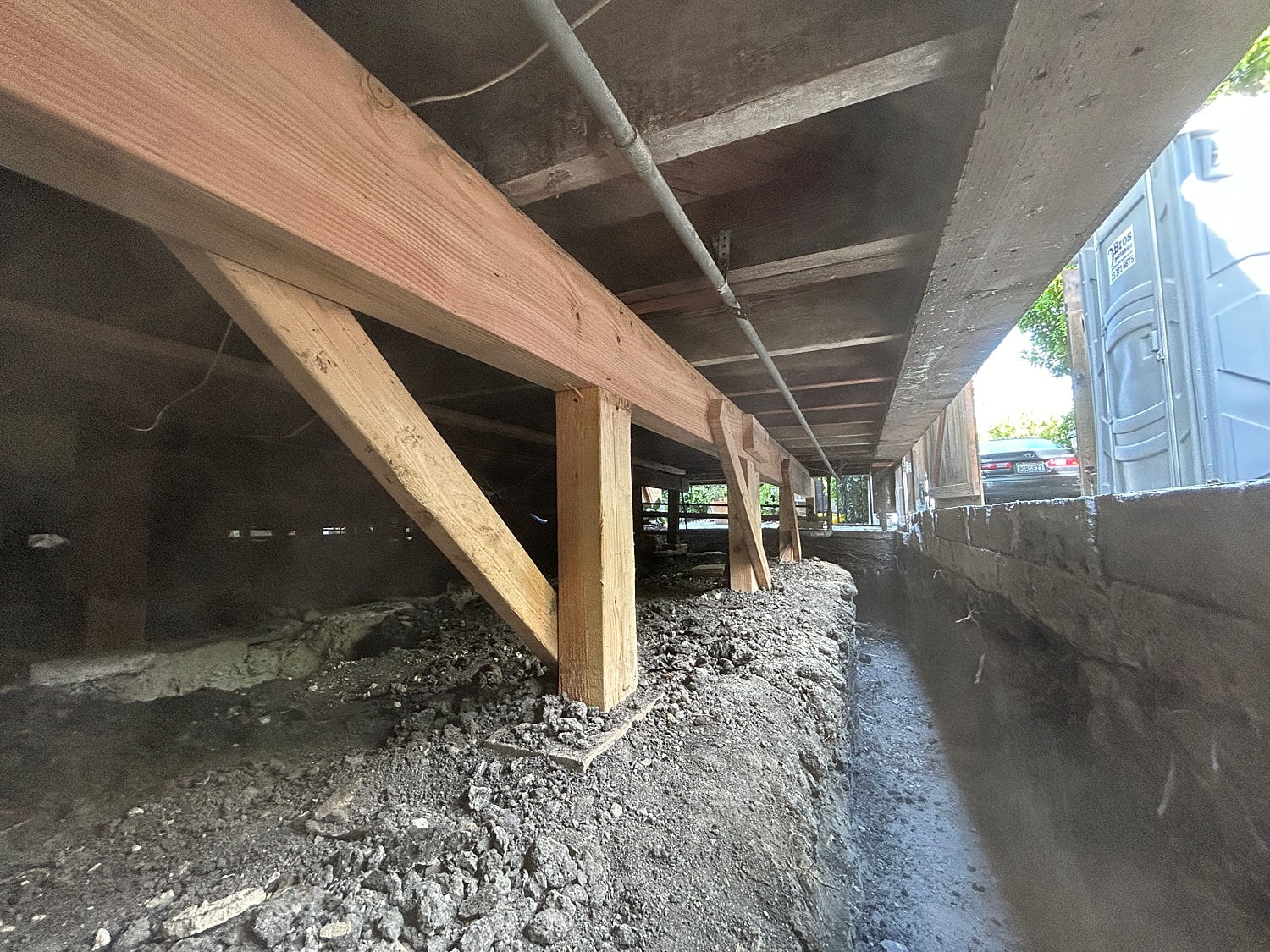 Underfloor construction with wooden beams and supports.