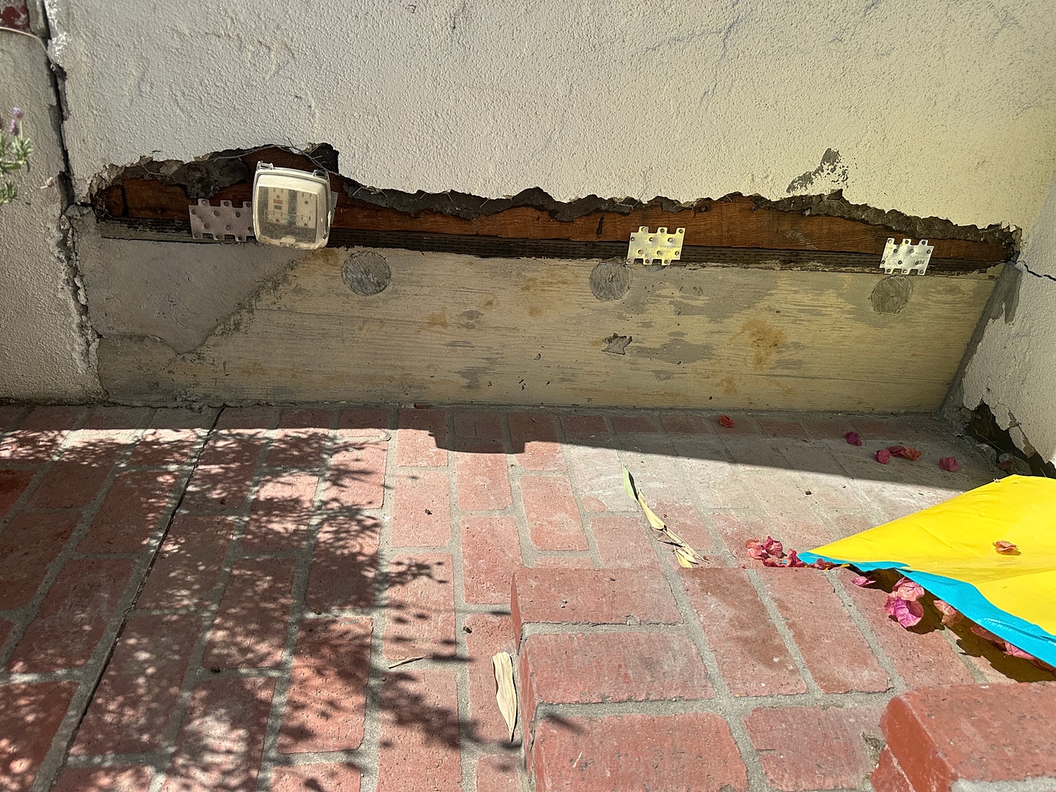 Damaged exterior wall with exposed wood.