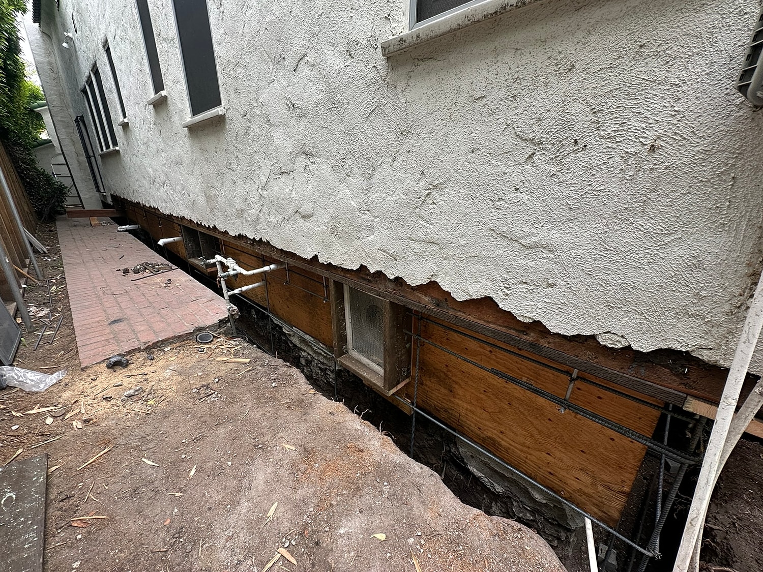Construction site with exposed foundation and plumbing.