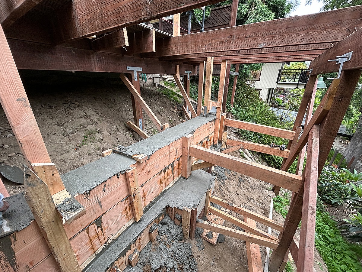 Foundation construction with wooden supports and concrete.