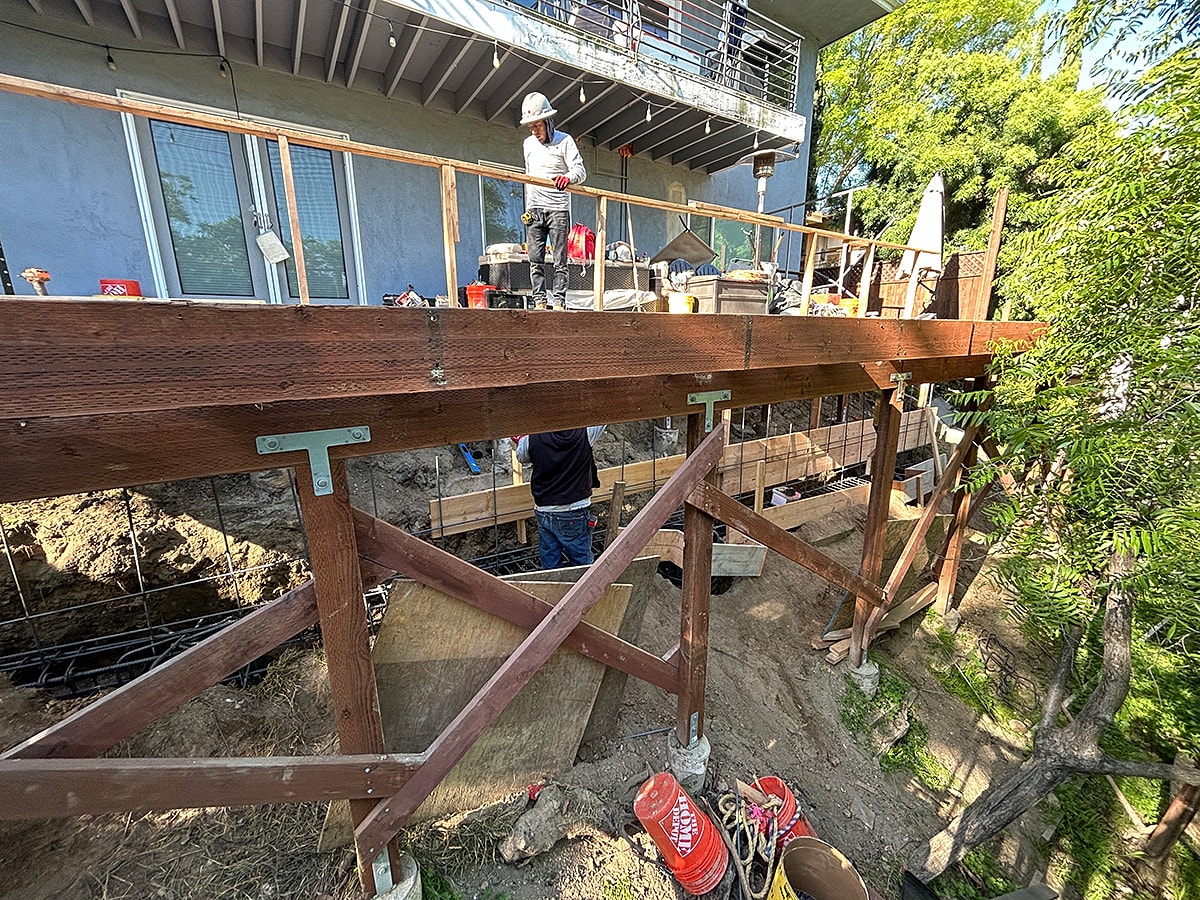 Construction workers on a wooden deck structure.