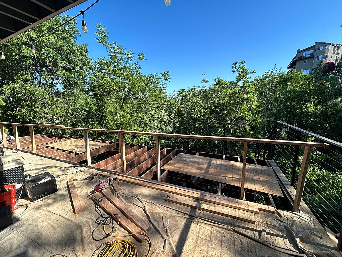 Deck construction in a green, wooded area.