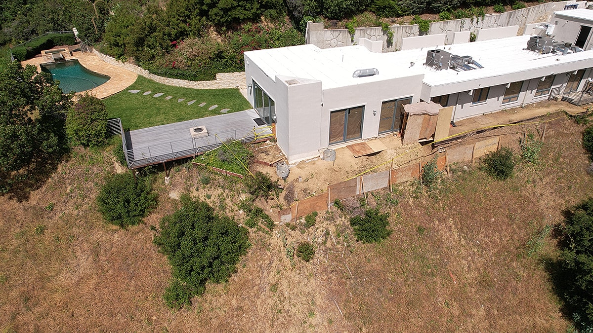 Modern house with pool and hillside view.
