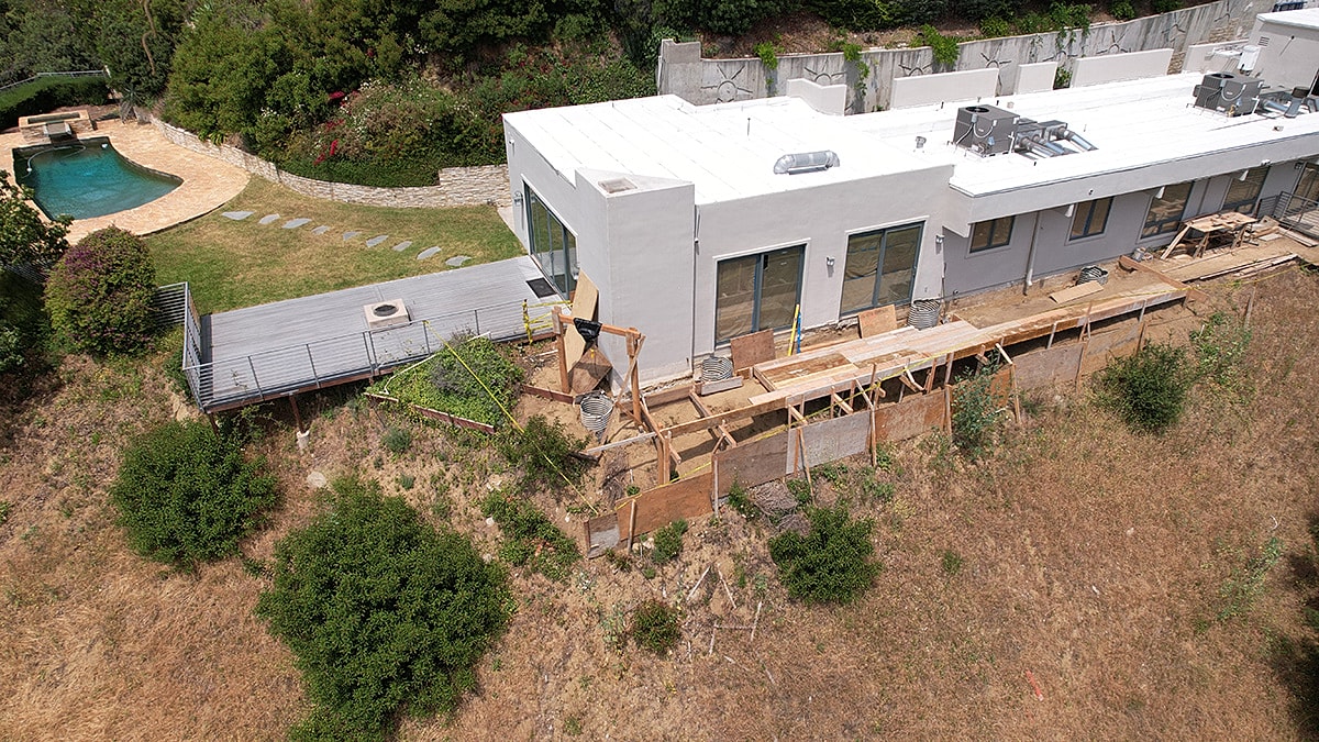 Aerial view of house with pool and construction.
