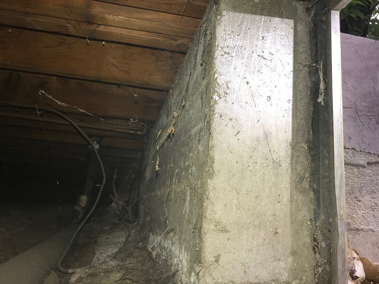 Underneath structure showing concrete and wood elements.