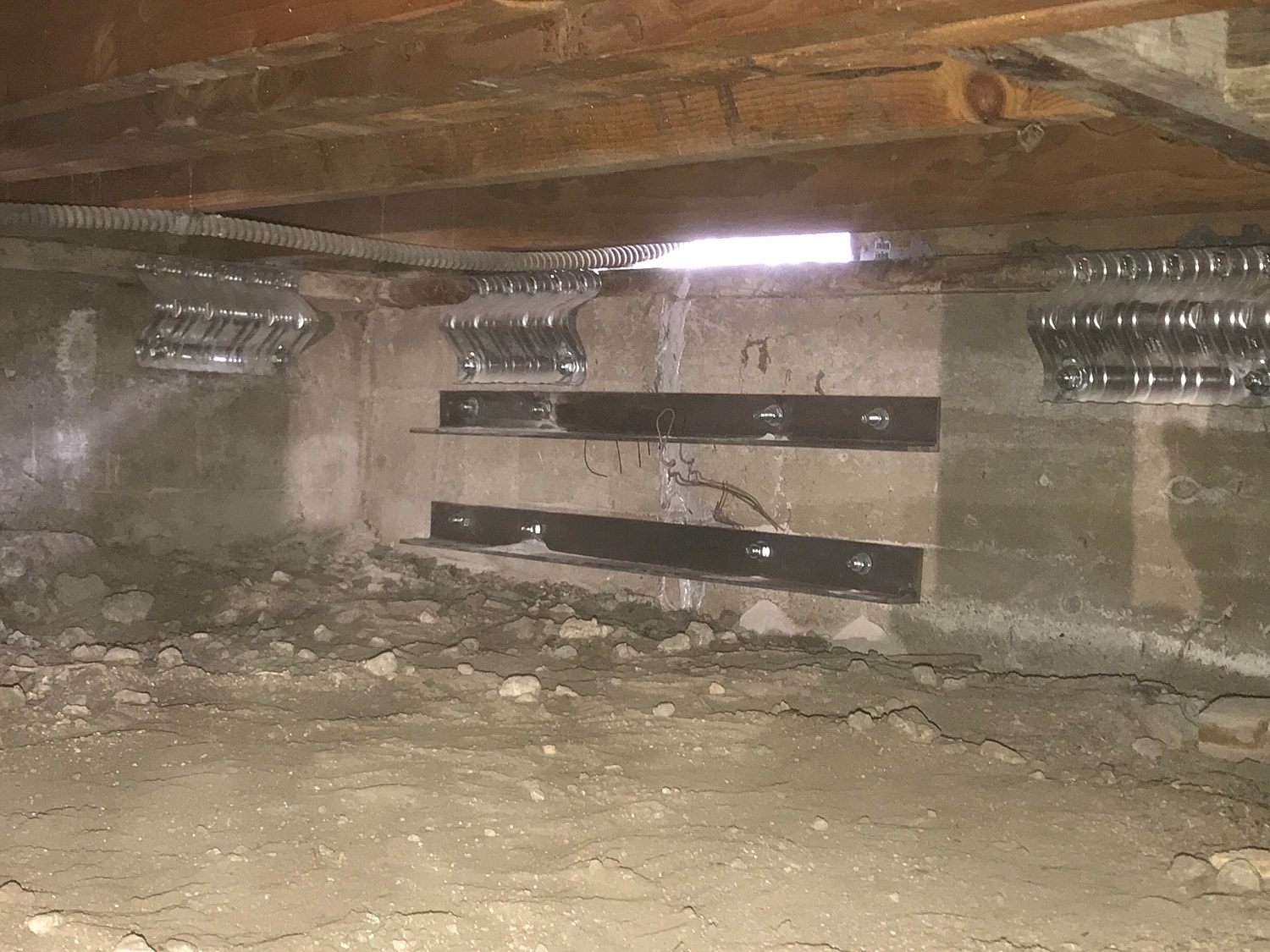Underneath a structure showing supports and ground.