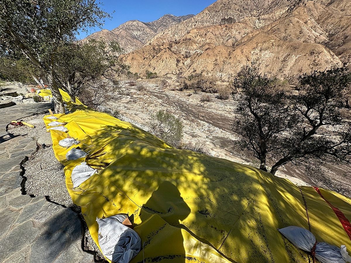 Yellow tarps along rocky terrain near mountains.