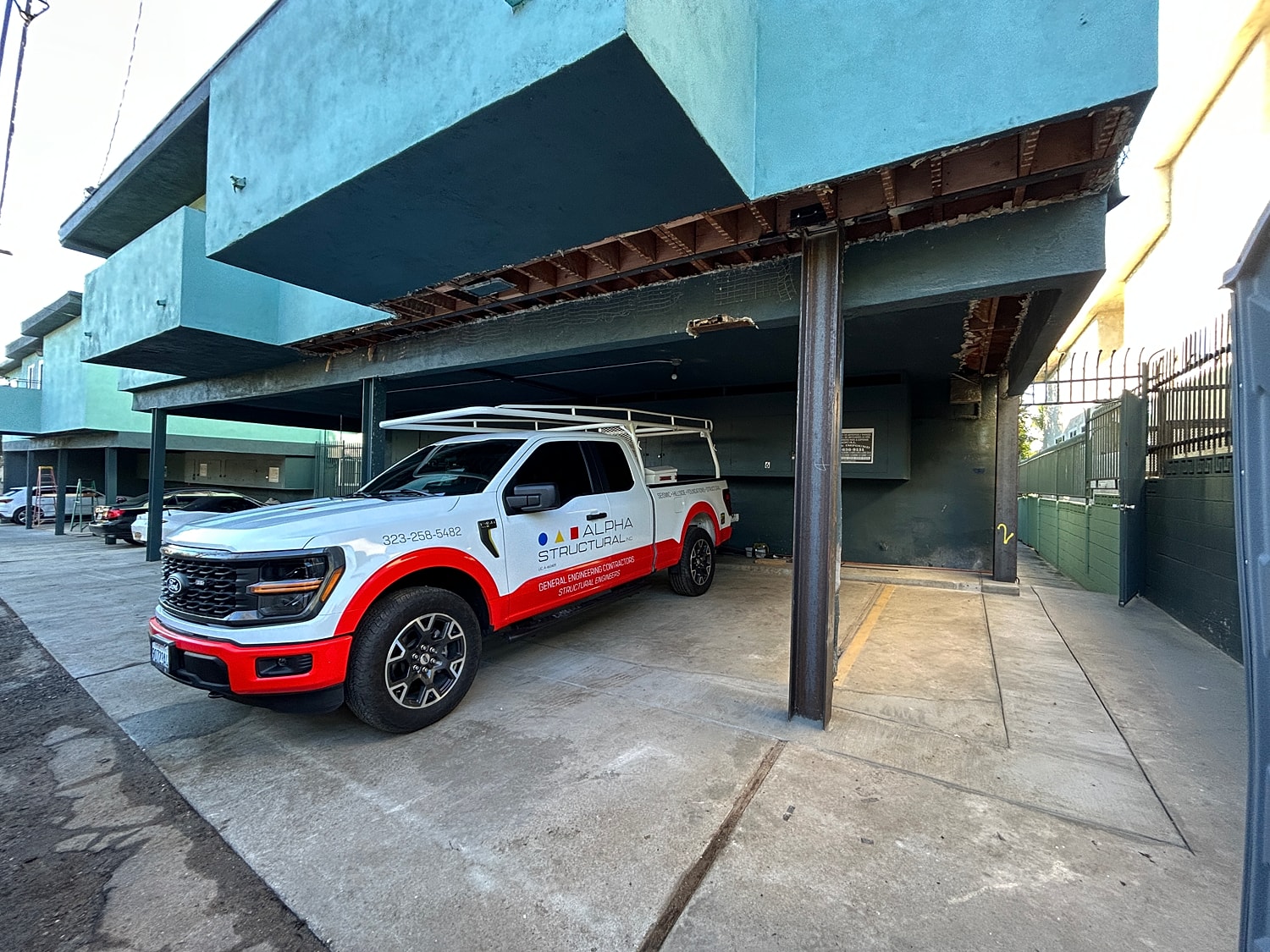 White and red truck parked under a building.
