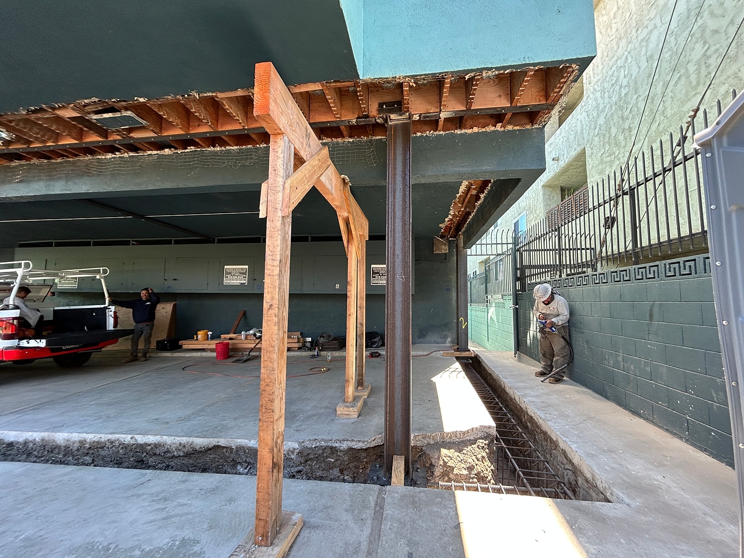 Construction site with workers and structural support.