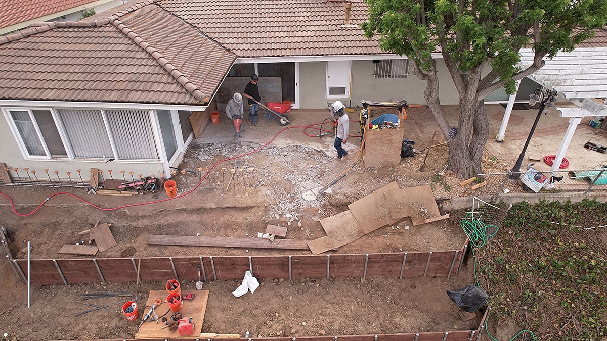 Construction workers performing yard renovation work.