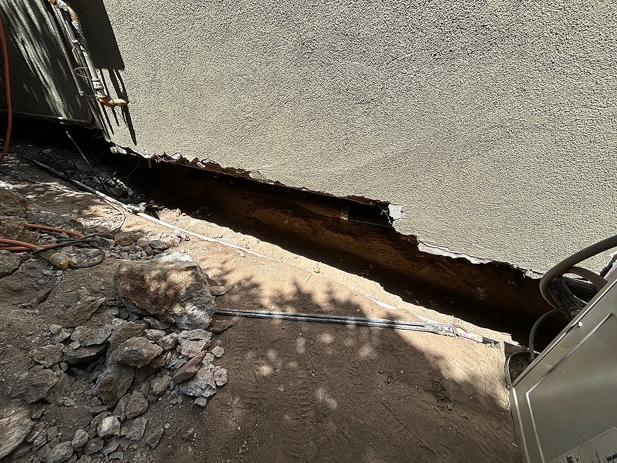 Cracked foundation with exposed trench area.