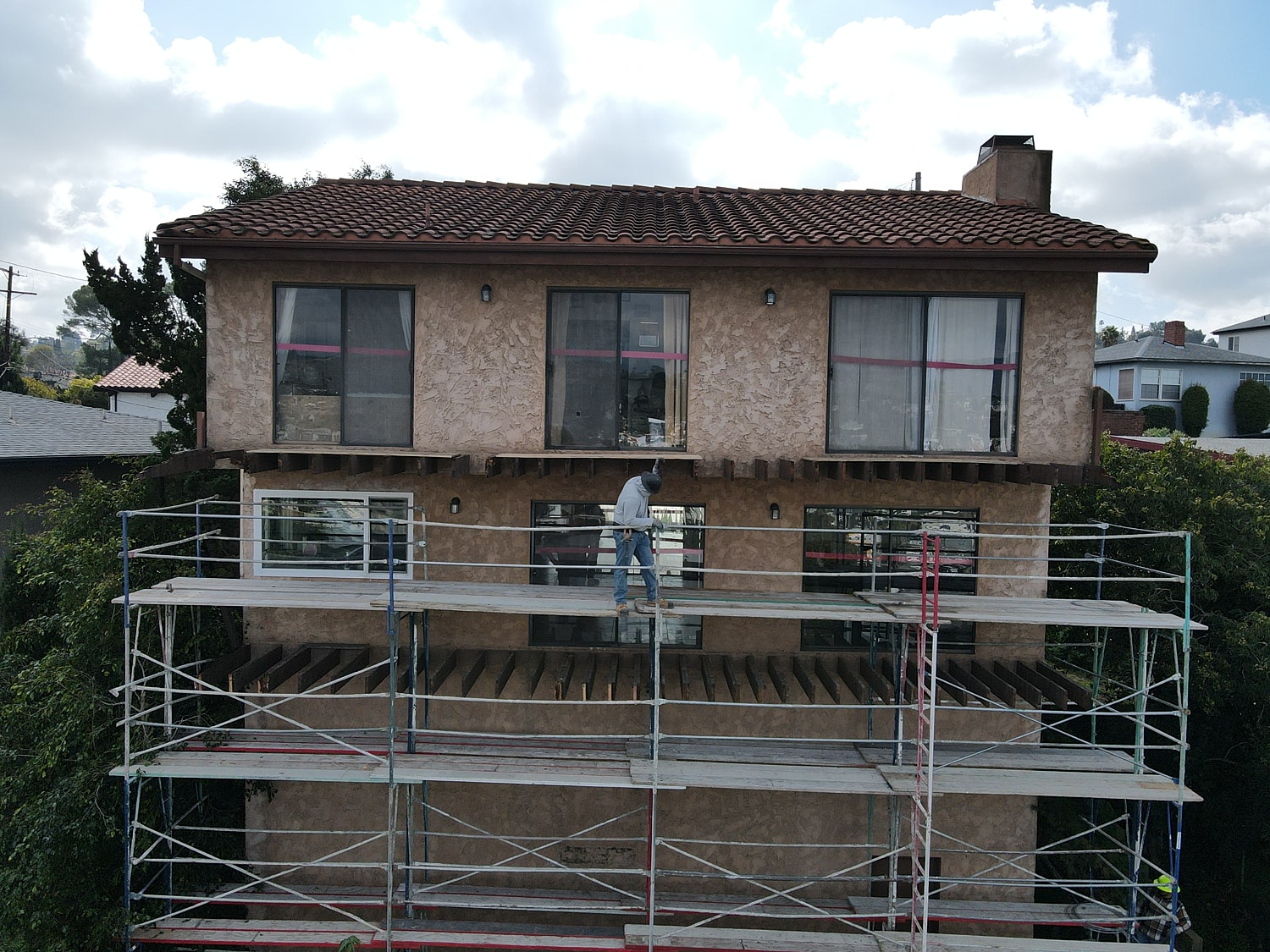 Construction worker on scaffolding at building exterior.
