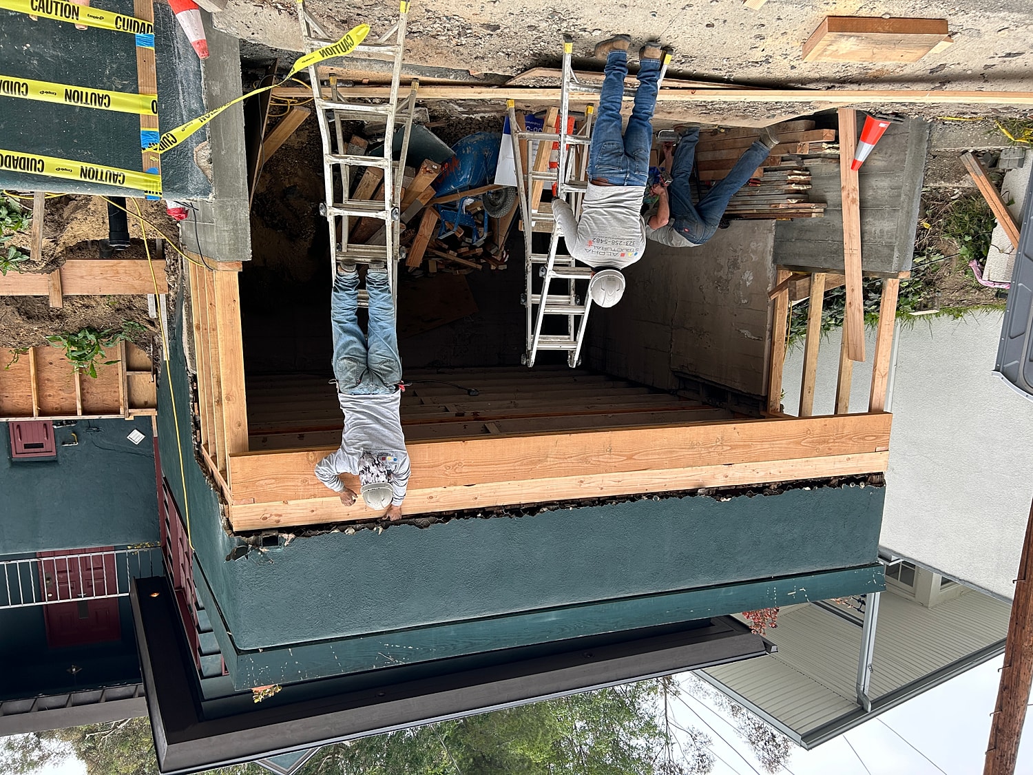 Construction workers building wooden structure outdoors.