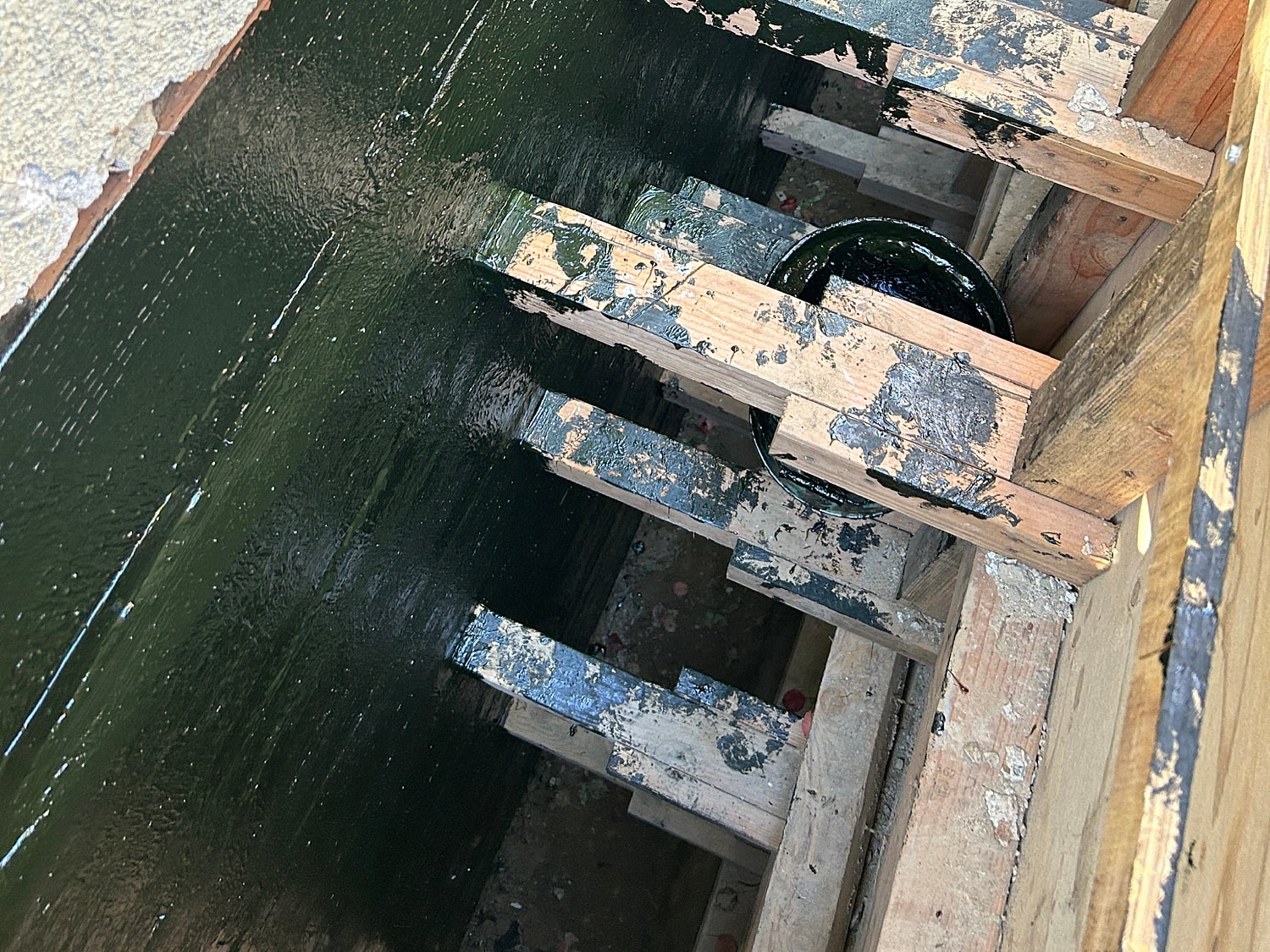 Wooden beams with green paint, viewed from above.