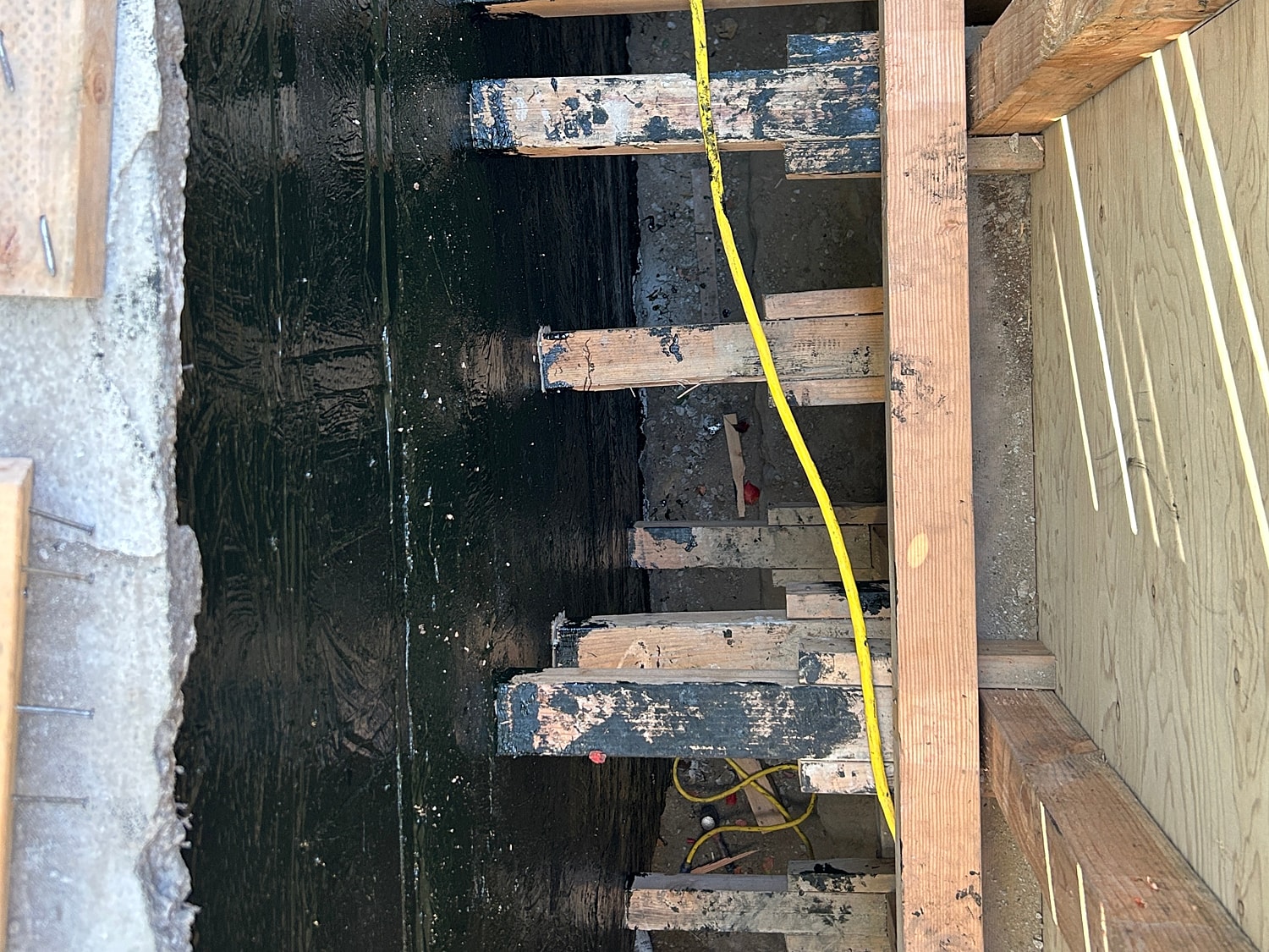 Construction site with wooden supports and cable.