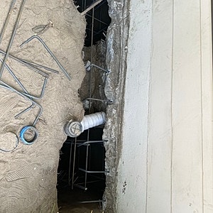 Construction site with exposed pipes and rebar.