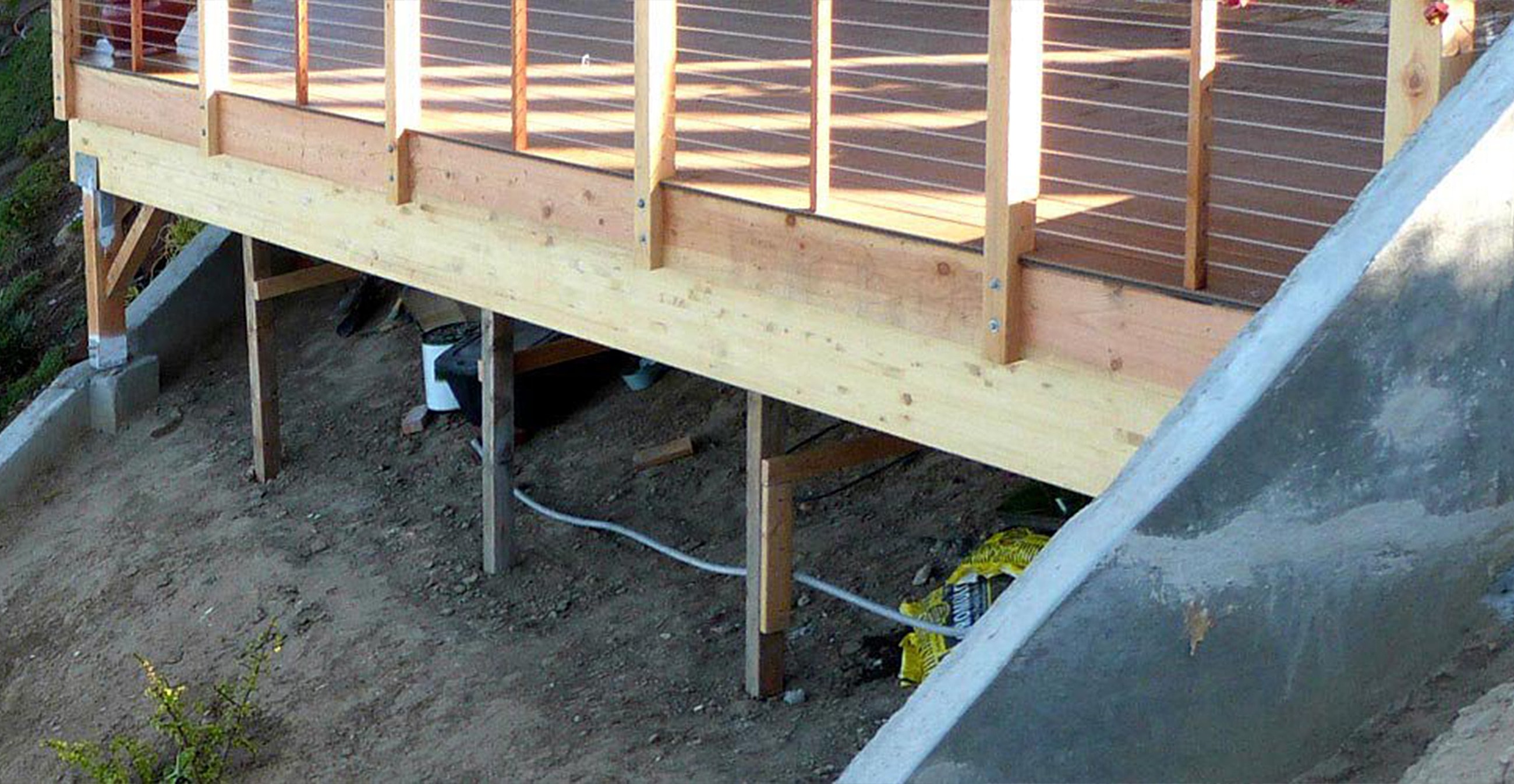 Wooden deck supported by posts above ground.