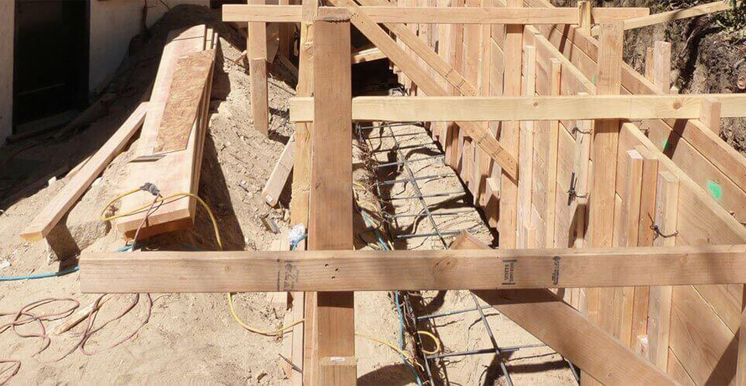 Construction site with wooden framing and materials.