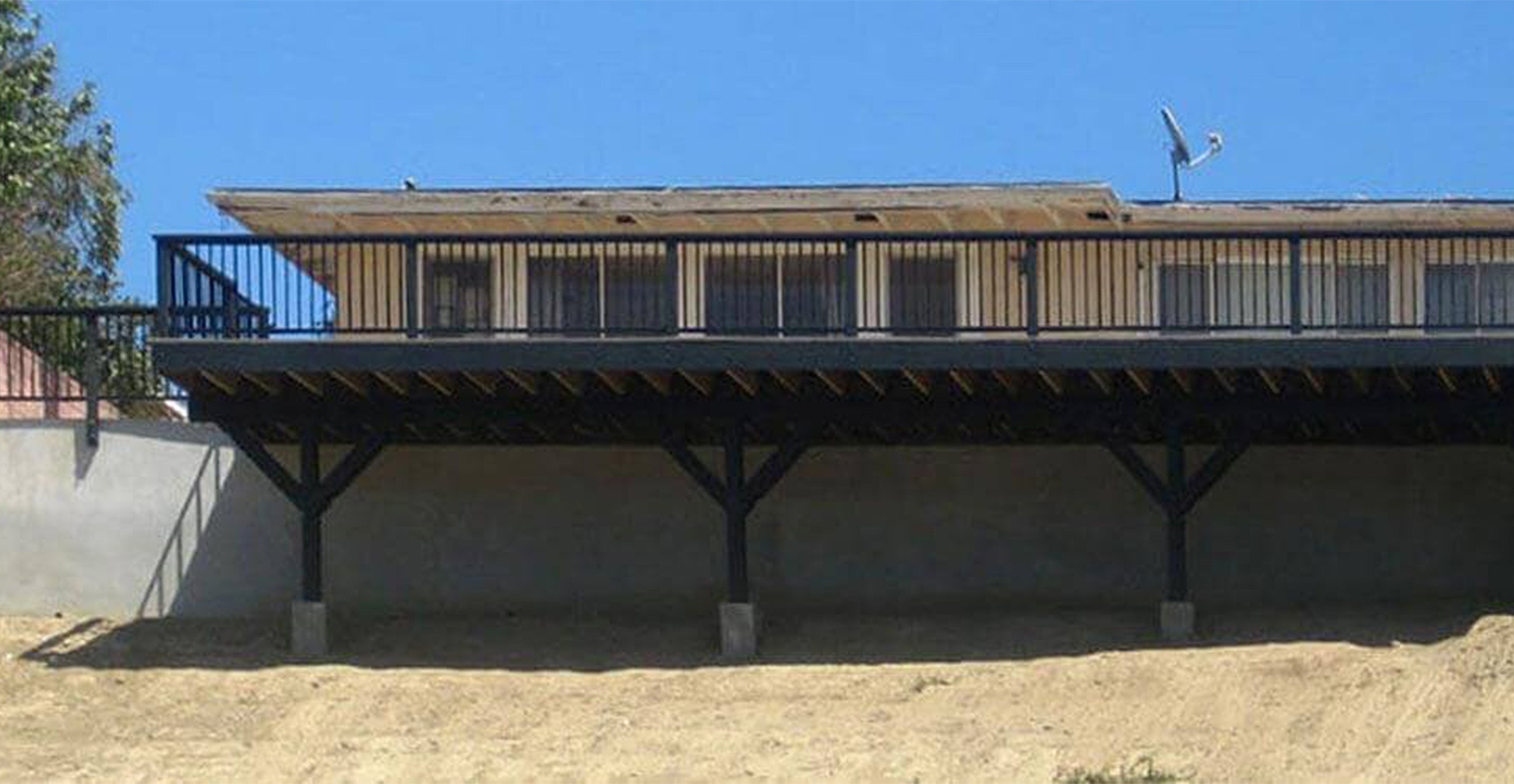 House with elevated balcony and satellite dish.