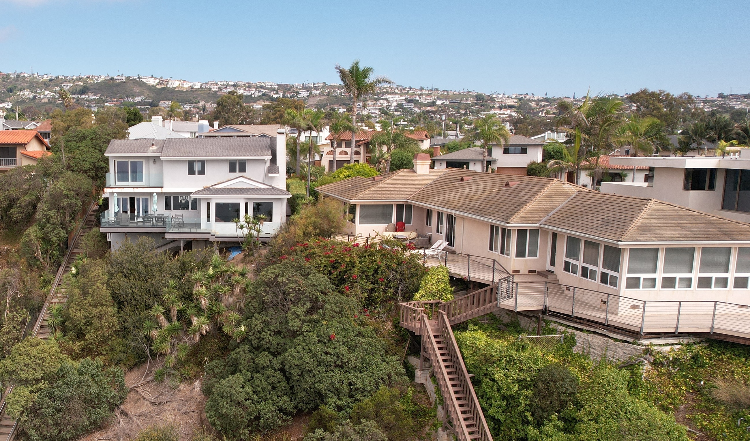 Clifftop homes overlooking lush coastal landscape.