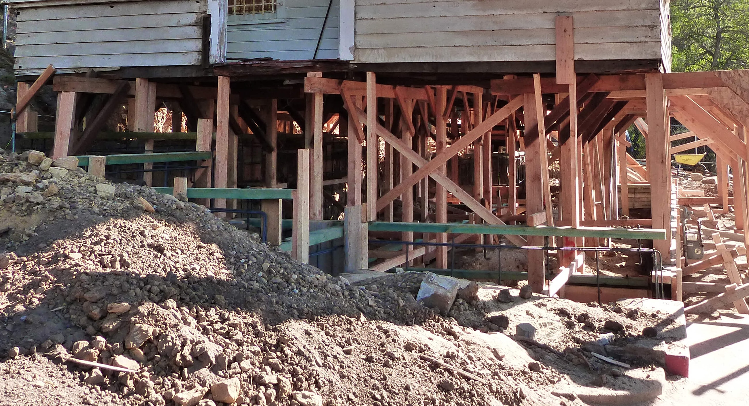 House under construction with exposed foundation supports.