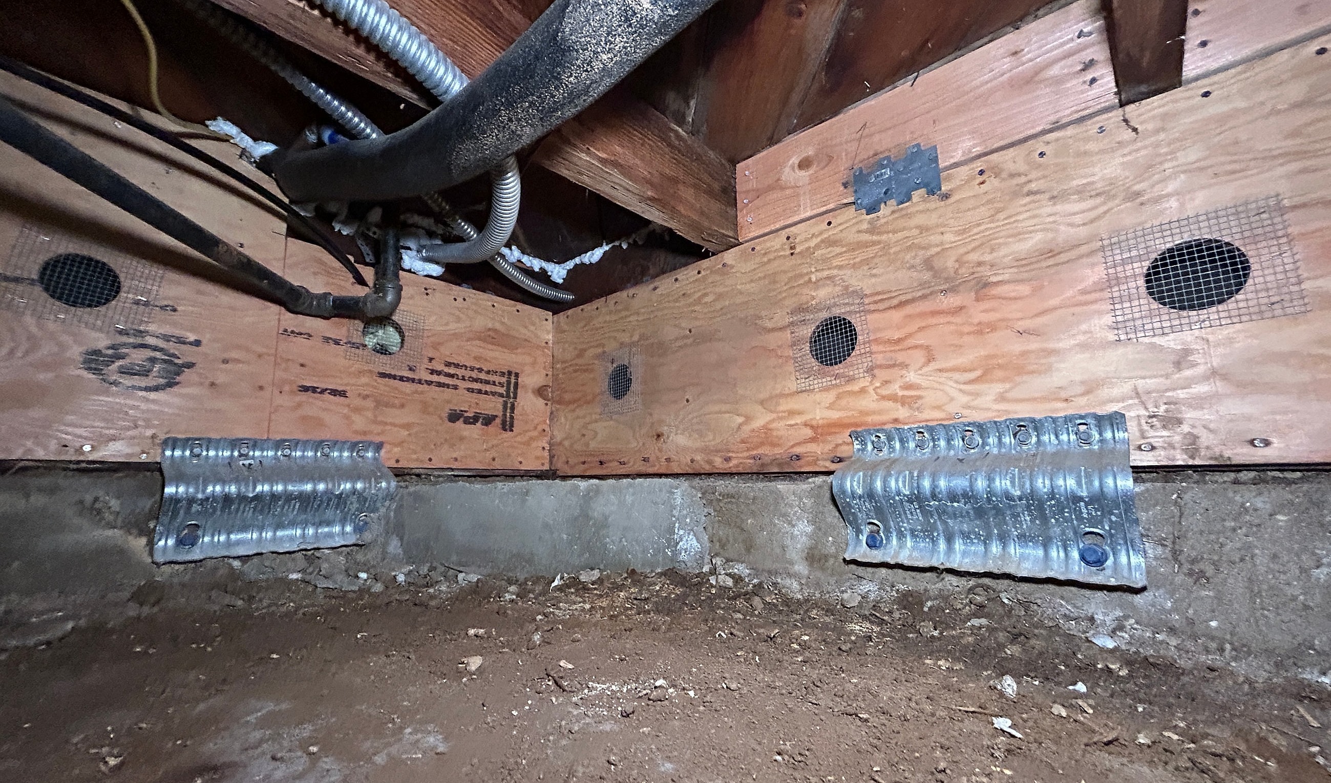 Basement space with ventilation and plumbing pipes.