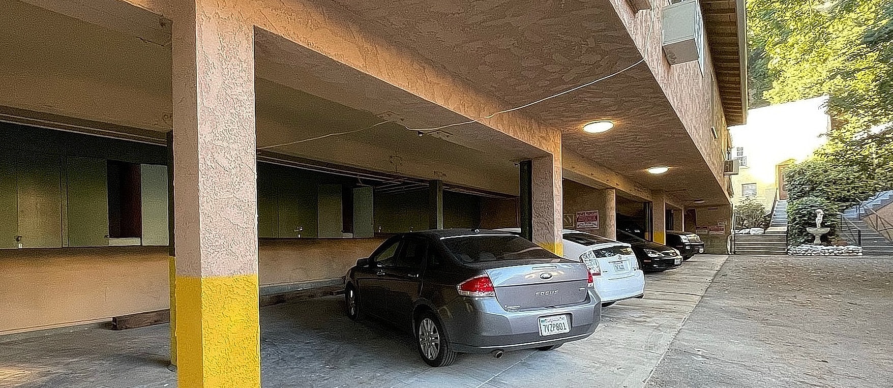 Parking garage with cars and yellow column.